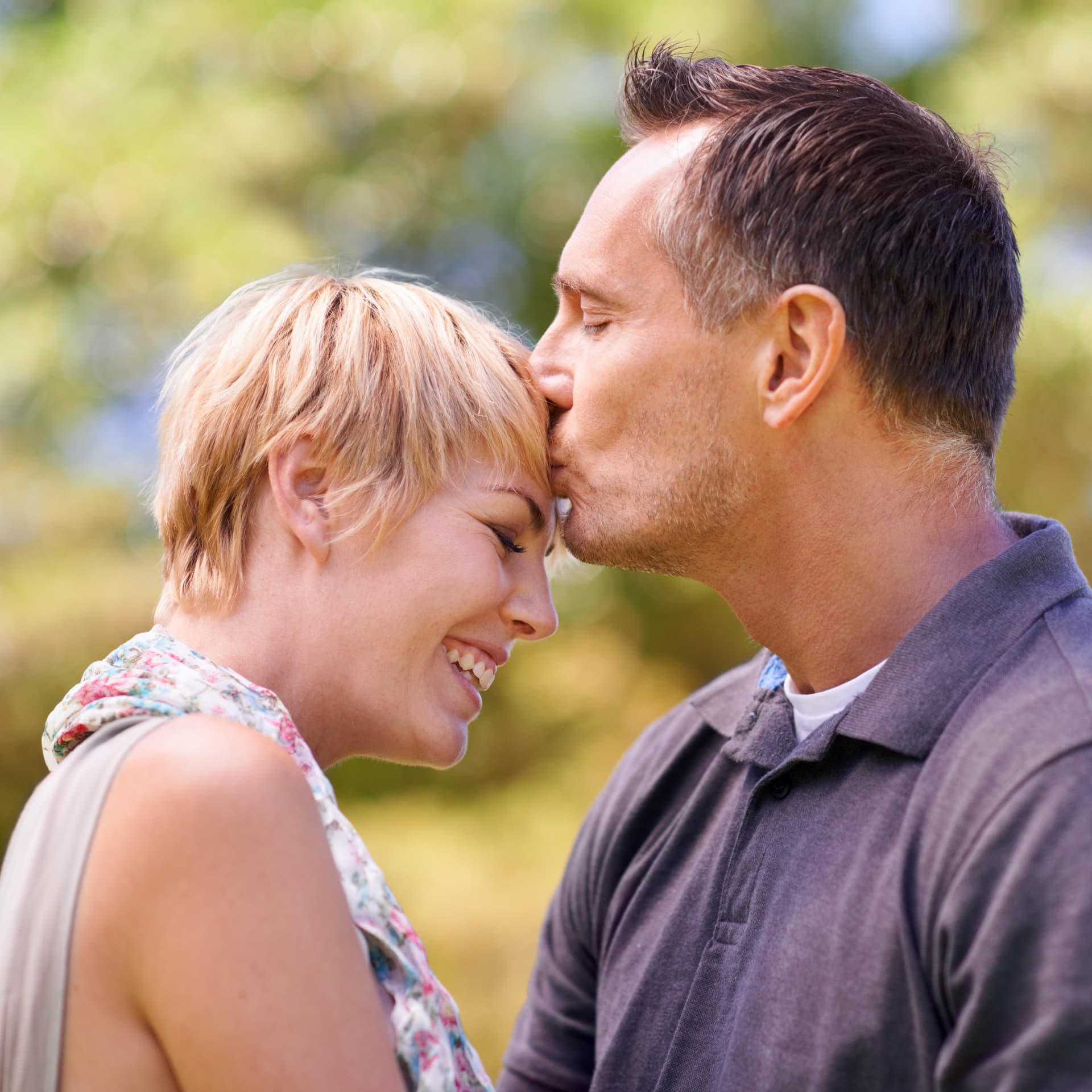 Casal sorrindo e compartilhando um momento íntimo ao ar livre